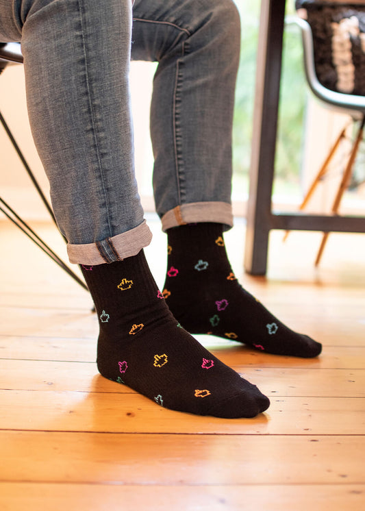 Ein Paar schwarze J.Clay Tennissocken mit bunten gestickten Hand-Cursor-Symbolen, die über den Stoff verstreut sind, und einem kleinen gelben geometrischen Symbol in der Nähe des oberen Randes für einen verspielten, modernen Touch. - Tennissocken