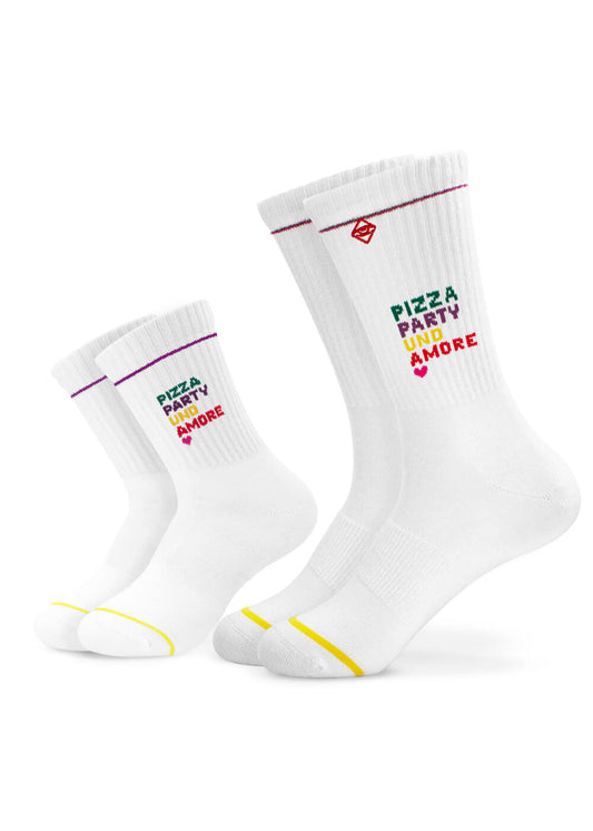 Ein Set aus zwei weißen J.Clay Crew Socken, eine klein, eine groß-ideale Mini Me Socken für Partner-Look. Mit "PIZZA PARTY AND SMORE" in grün, lila, rot und bunten Streifen mit gelben und lila Zehenakzenten.