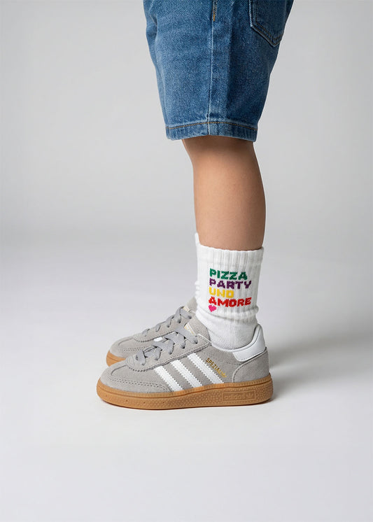 Kind in Pizza Party - Mini-Socken von J.Clay, in Jeans-Shorts und grauen Turnschuhen.