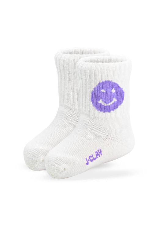 Ein Paar weiße, gerippte Babysocken von J.Clay mit einem lila Smiley an der Seite und dem Schriftzug "J-Clay" in lila an der Sohle, ideal für Kinder von 0-4 Jahren.