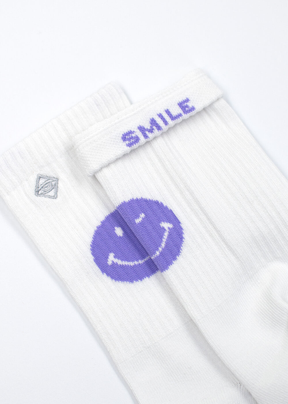 J.Clay Purple Smile Tennissocken: weiß mit einem lila Smiley und "SMILE" auf dem Bündchen.