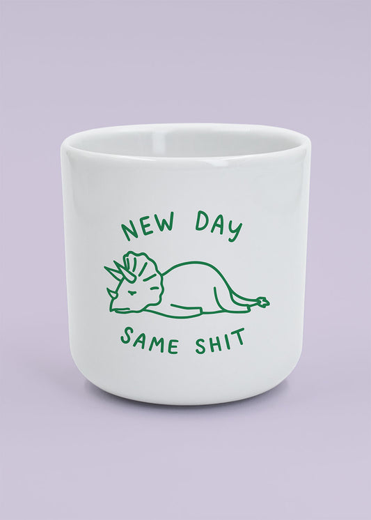 J.Clay New Day – Tasse mit Dino und dem Spruch „new day same shit“ auf helllila Hintergrund.
