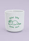 J.Clay New Day – Tasse mit Dino und dem Spruch „new day same shit“ auf helllila Hintergrund.