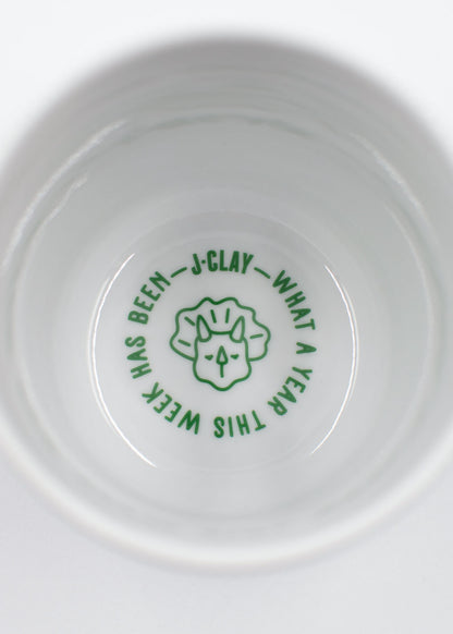 Weiße Tasse: J.Clay New Day – Tasse, eine lustige Tasse mit Kritzeleien und grüner Schrift.