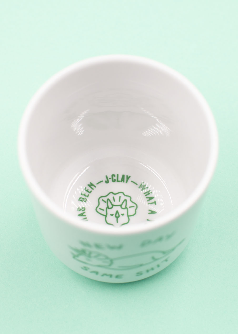 J.Clay New Day Tasse, weiße Keramik mit mintgrünen Akzenten, grüner Beschriftung und schlichtem Motiv auf der Innenseite.