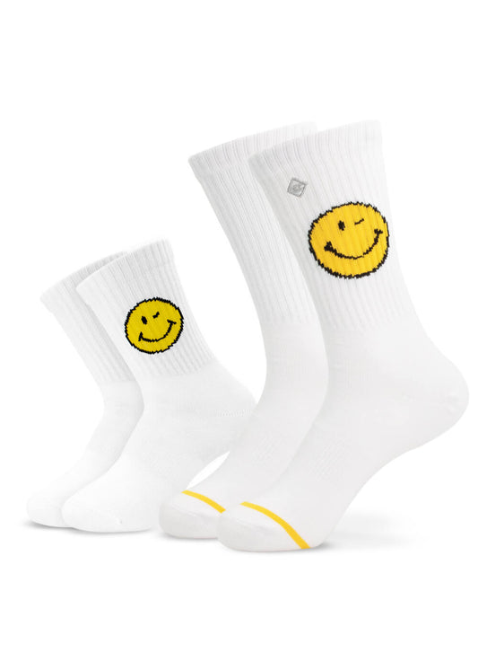 Zwei Paar weiße J.Clay-Socken - ein kleines und ein großes - zeigen gelbe Smiley-Gesichter am oberen Rand und einen dezenten gelben Zehenstreifen, perfekt für einen Partner-Look mit unseren Mini Me Socken!.