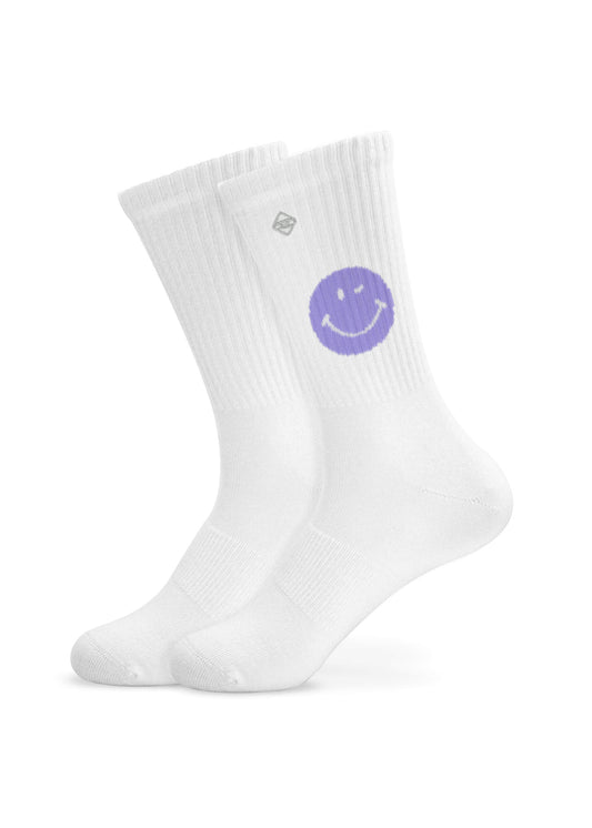 Ein Paar weiße J.Clay Tennissocken mit einem lilafarbenen Smiley an der Spitze und einem kleinen quadratischen Logo über dem Knöchel, die aufrecht auf einem schlichten weißen Hintergrund stehen.