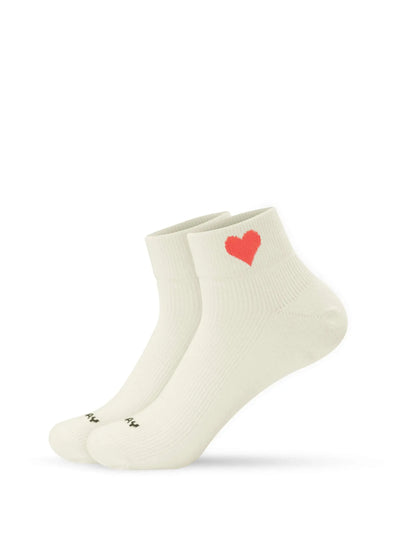 Ein Paar beige Sneaker Socken von J.Clay, gefertigt aus einer weichen Baumwollmischung und mit einem kleinen roten Herz-Motiv am oberen Ende jeder Socke.