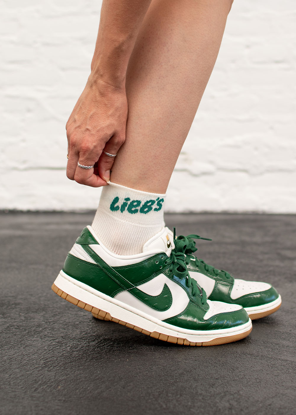 Handgefertigte Lieb’s – Sneaker-Socken „High“ von J.Clay, grüner Nike-Sneaker, schwarzer Boden.