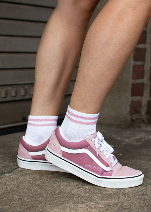 Person in „J.Clay Glitter Stripes“ – SSH-Socken mit rosa Streifen und rosa Sneakers auf Beton.
