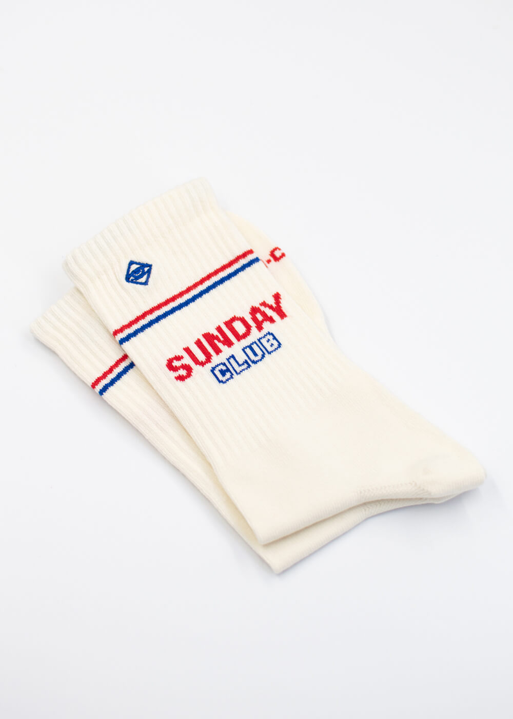Zwei cremefarbene J.Clay Sunday Club Socken mit roten und blauen Streifen und der Aufschrift SUNDAY CLUB.