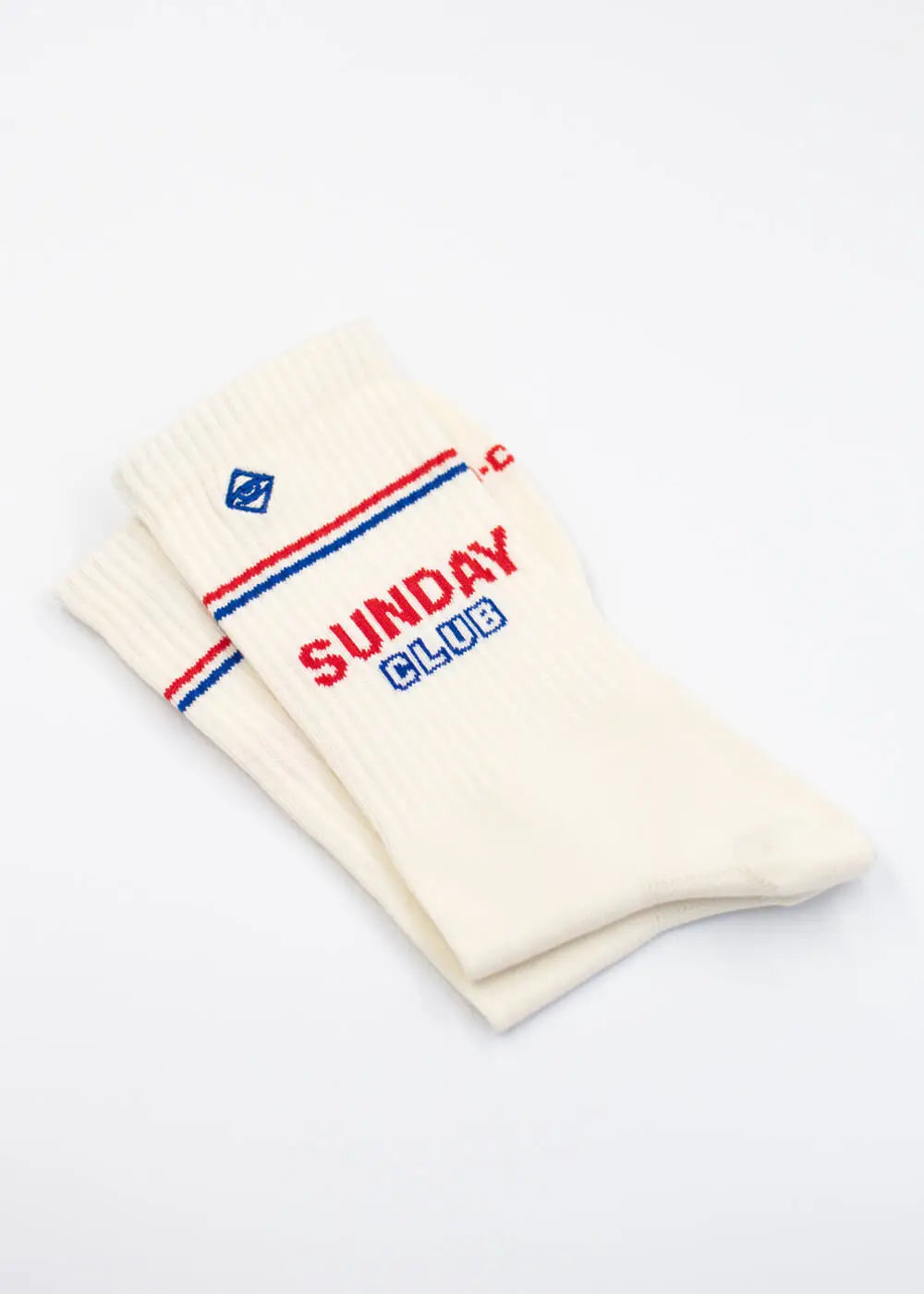 Zwei cremefarbene J.Clay Sunday Club Socken mit roten und blauen Streifen und der Aufschrift SUNDAY CLUB.