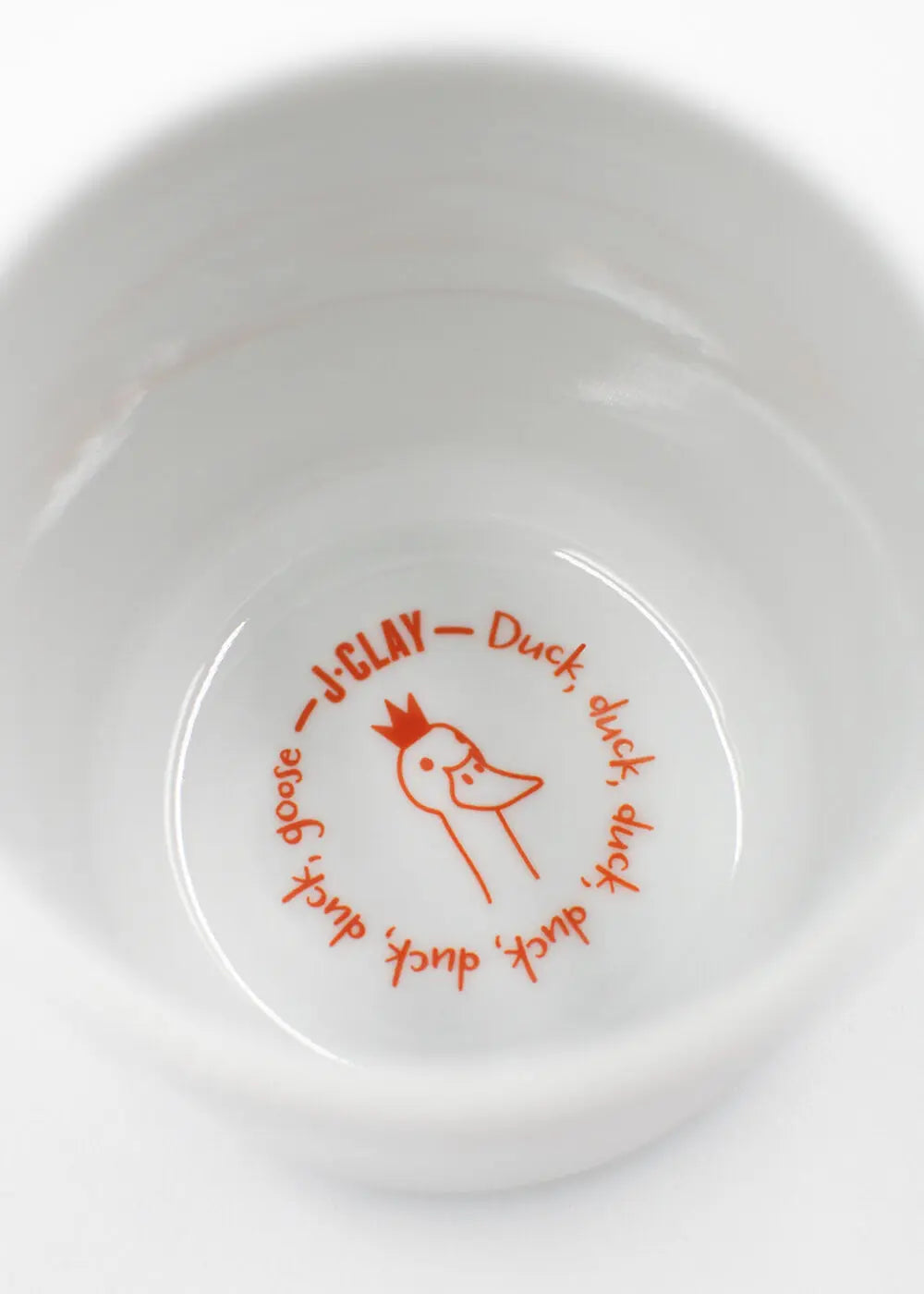 Weißer "What the Duck - Tasse" Becher von J.Clay mit einer Entenzeichnung und Text.