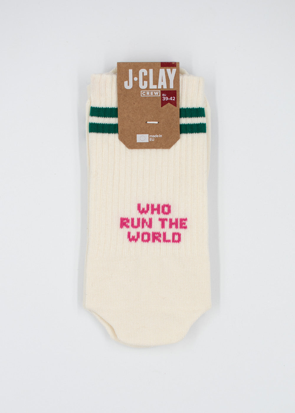 Cremefarbene Socken von J.Clay mit grünen Streifen und dem rosa Schriftzug „WHO RUN THE WORLD“ auf der Vorderseite.