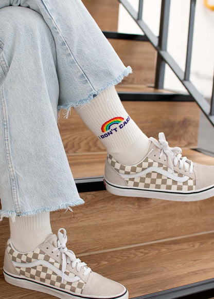 Ich trage karierte Vans, ausgefranste Jeans und J.Clay „I don’t care“-Tennissocken mit Regenbogenmuster.