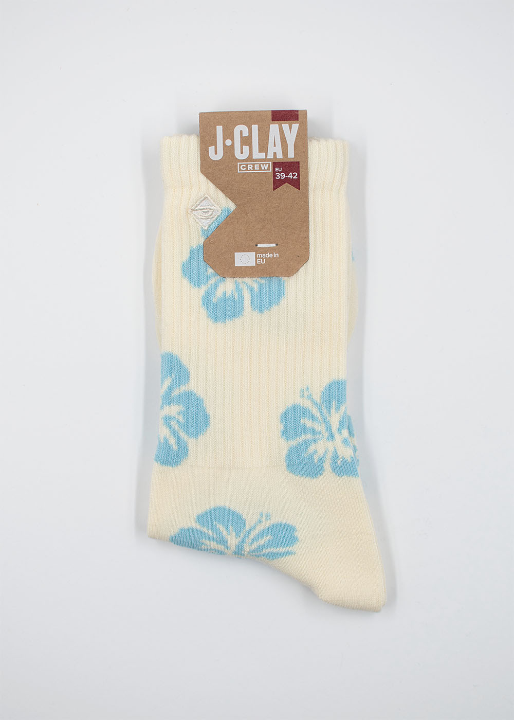 Cremefarbene Socken mit blauer Hibiskusblüte von J.Clay, in brauner Verpackung.