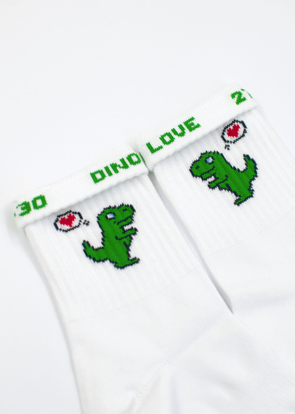 Weiße J.Clay Dino Love - Kids Socken mit grünen Dinos und roten Herz-Sprechblasen.