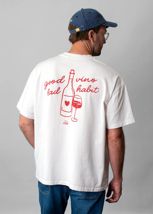 Mann in einem „J.Clay Good Vino“-T-Shirt mit Weinmotiv und blauer Kappe, von hinten gesehen; Unisex-Modell.