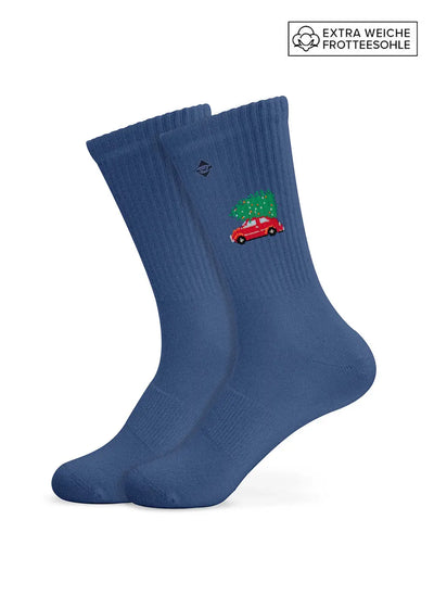 „Driving Home for Christmas“ von J. Clay: Blaue Socken, rotes Auto, Weihnachtsbaum und weiche Sohlen – das perfekte Weihnachtsgeschenk.