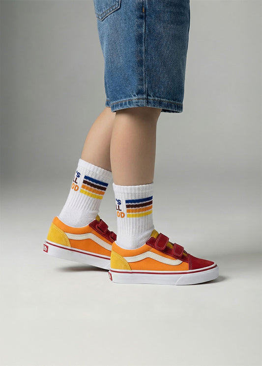 Kind in Jeans-Shorts trägt J.Clay All Good - Mini-Socken und bunte Turnschuhe auf grauem Hintergrund.