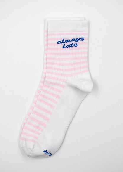 J.Clay immer zu spät – Midi: weiße Socke mit rosa Streifen, oben in Blau die Aufschrift „always late“.