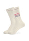 Ein Paar cremefarbene, gerippte J.Clay Tennissocken mit dreifacher Stickerei "amore" in Rot, Rosa und Lila an der Seite und einem dezenten kastanienbraunen Streifen am oberen Rand.