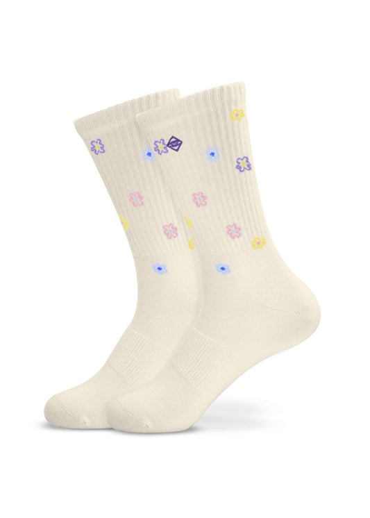 Ein Paar cremefarbene Tennissocken von J.Clay mit kleinen pastellfarbenen Blumenmustern in Lila, Blau, Rosa und Gelb, die über den Stoff verstreut sind und auf weißem Hintergrund erscheinen.