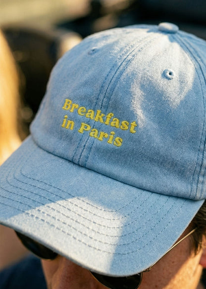 J.Clay Breakfast in Paris Cap - hellblau mit gelbem Text, perfekt für Sommertage.