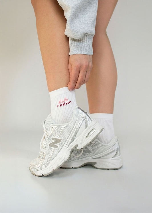 Person in J.Clay Hola Chérie - Midi weiße Socken, graue Jogginghose und weiße Turnschuhe.