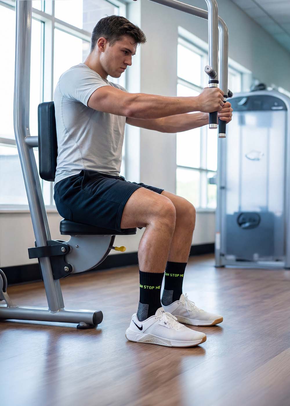 Mann trainiert an Chest Press, trägt J.Clay Nothing Can Stop Me Sportsocken in Schwarz.