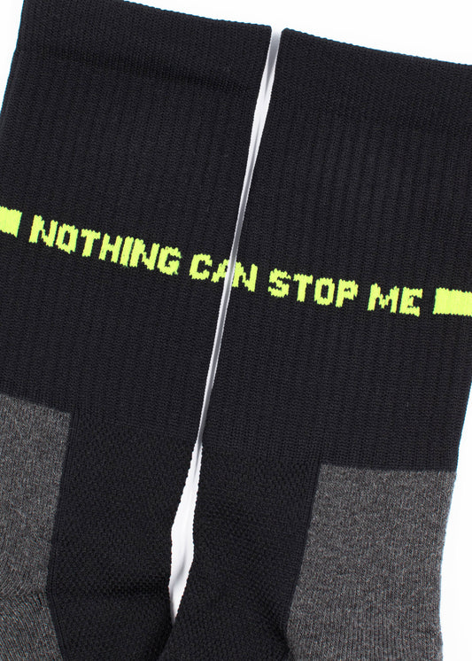 Ein Paar schwarze und graue J.Clay Sportsocken nebeneinander, mit dem Schriftzug "NOTHING CAN STOP ME" in leuchtendem Gelb-Grün auf den Oberseiten, aus atmungsaktivem Material mit gepolsterter Sohle für optimalen Tragekomfort.