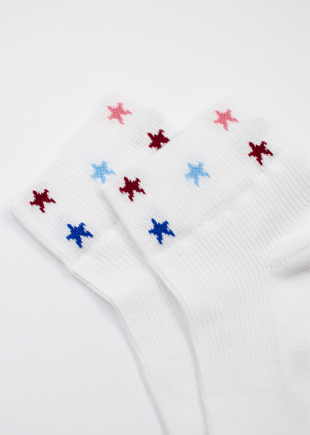 J.Clay Stars – SSH: weiße Socken mit roten, blauen und rosa Sternen am Sockenrand.