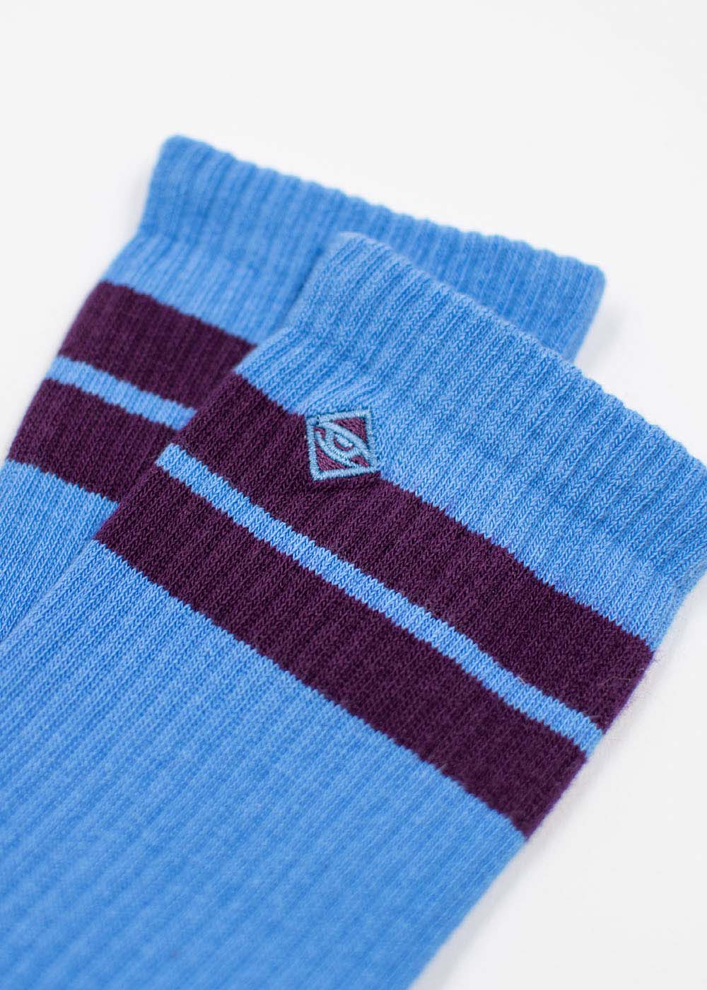 J.Clay True Sky Grape Tennissocken: Blaue Socken mit violetten Streifen und Rautenlogo.