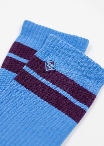 J.Clay True Sky Grape Tennissocken: Blaue Socken mit violetten Streifen und Rautenlogo.