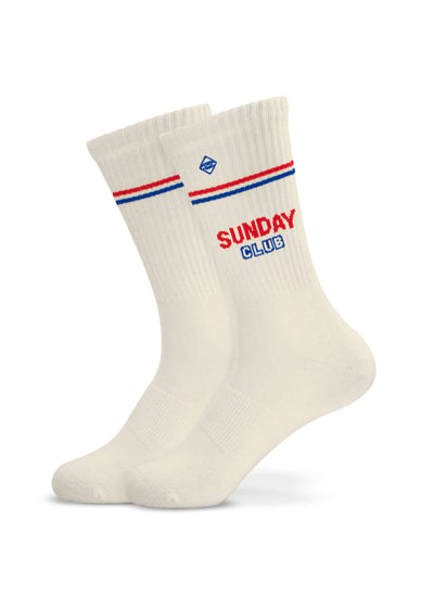 Ein Paar weiße J.Clay Tennissocken mit roten und blauen Streifen im oberen Bereich und der Aufschrift "SUNDAY CLUB" in passender roter und blauer Schrift an der Seite.